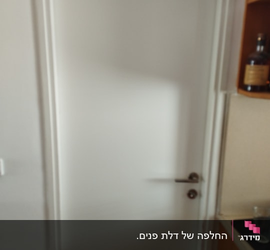 דלת לבנה עם ידית מתכת כסופה